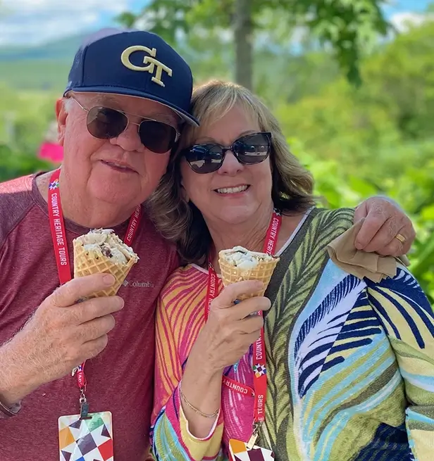 » Country Heritage Tours » Country Heritage Tours Happy husband and wife couple holding ice cream cones and smiling while wearing their tour badges