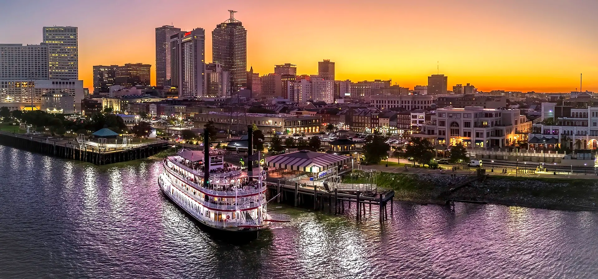 » Country Heritage Tours » Country Heritage Tours Riverboat leaving the dock with a cityscape in the background at Sunset