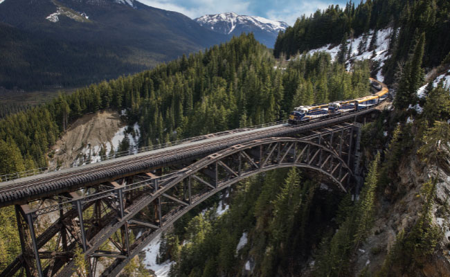 » Country Heritage Tours Rocky Mountaineer train passing over a tall bridge in the Canadian Rockies