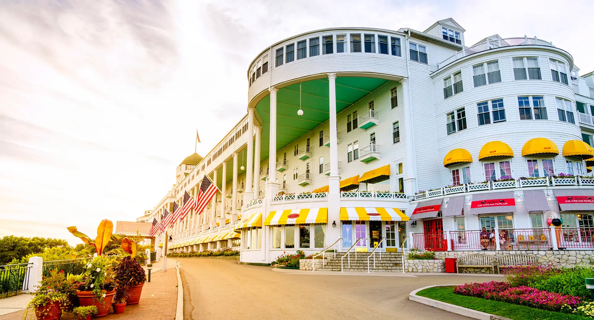 » Country Heritage Tours » Country Heritage Tours Mackinac Island white building with yellow awnings and colorful gardens